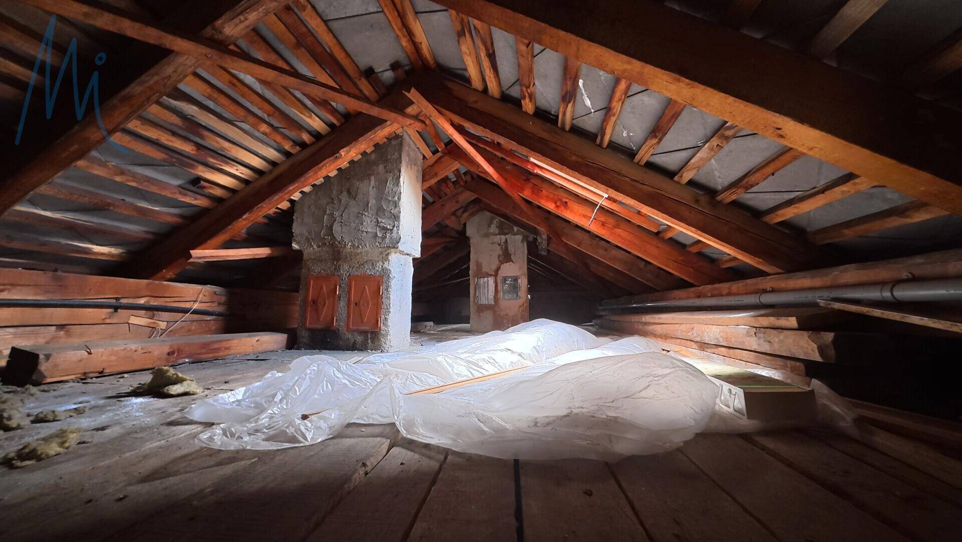 Unausgebauter Dachboden mit sichtbaren Holzbalken und Lagerfläche.