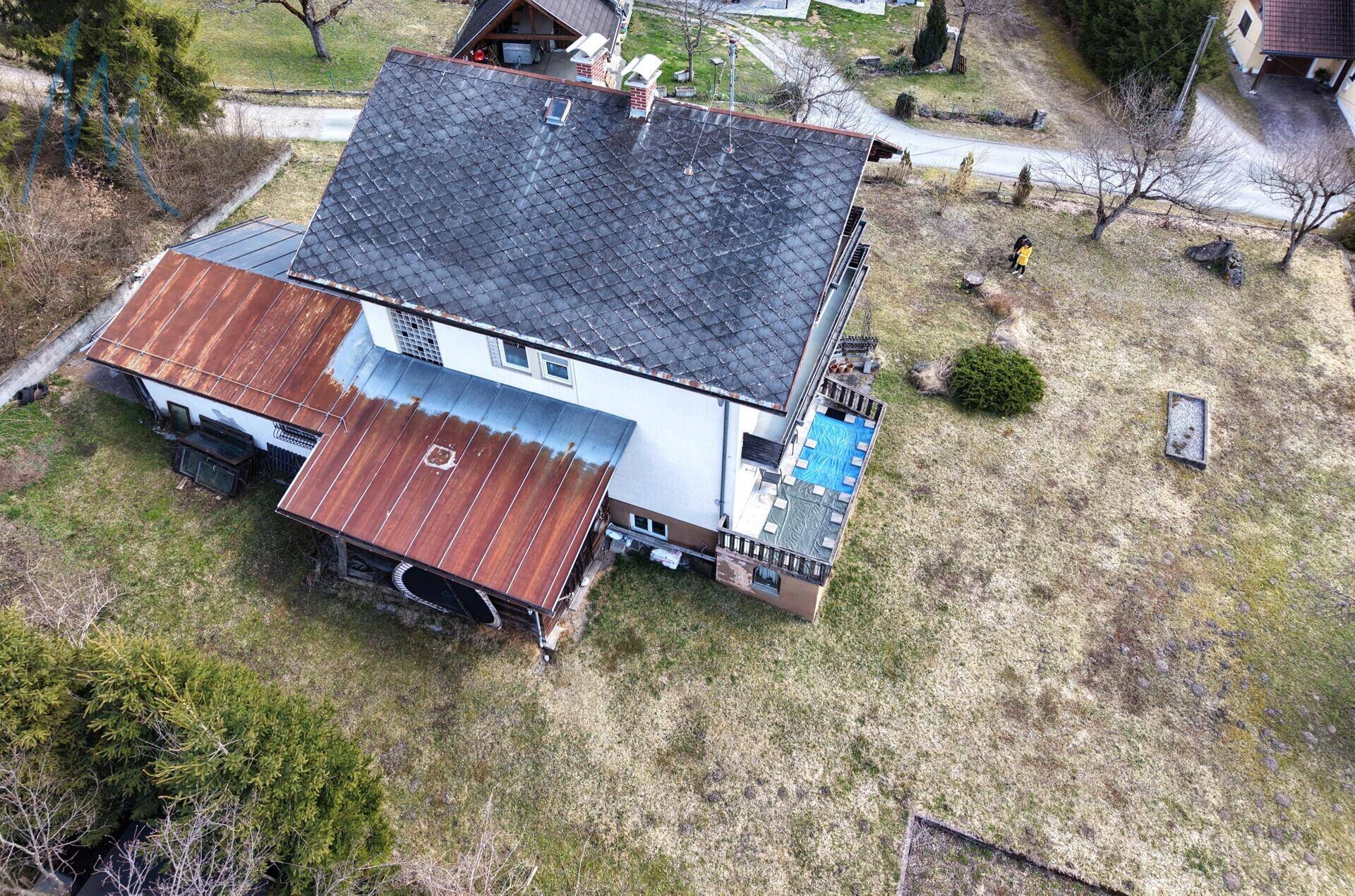 Luftaufnahme des Anwesens mit Wohnhaus, Nebengebäuden und großem Grundstück.