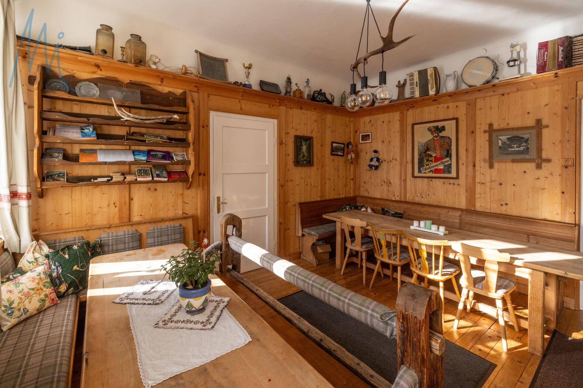 Gemütlicher Speisebereich mit holzgetäfelten Wänden, Eckbänken und traditioneller Dekoration, ideal für gesellige Runden.