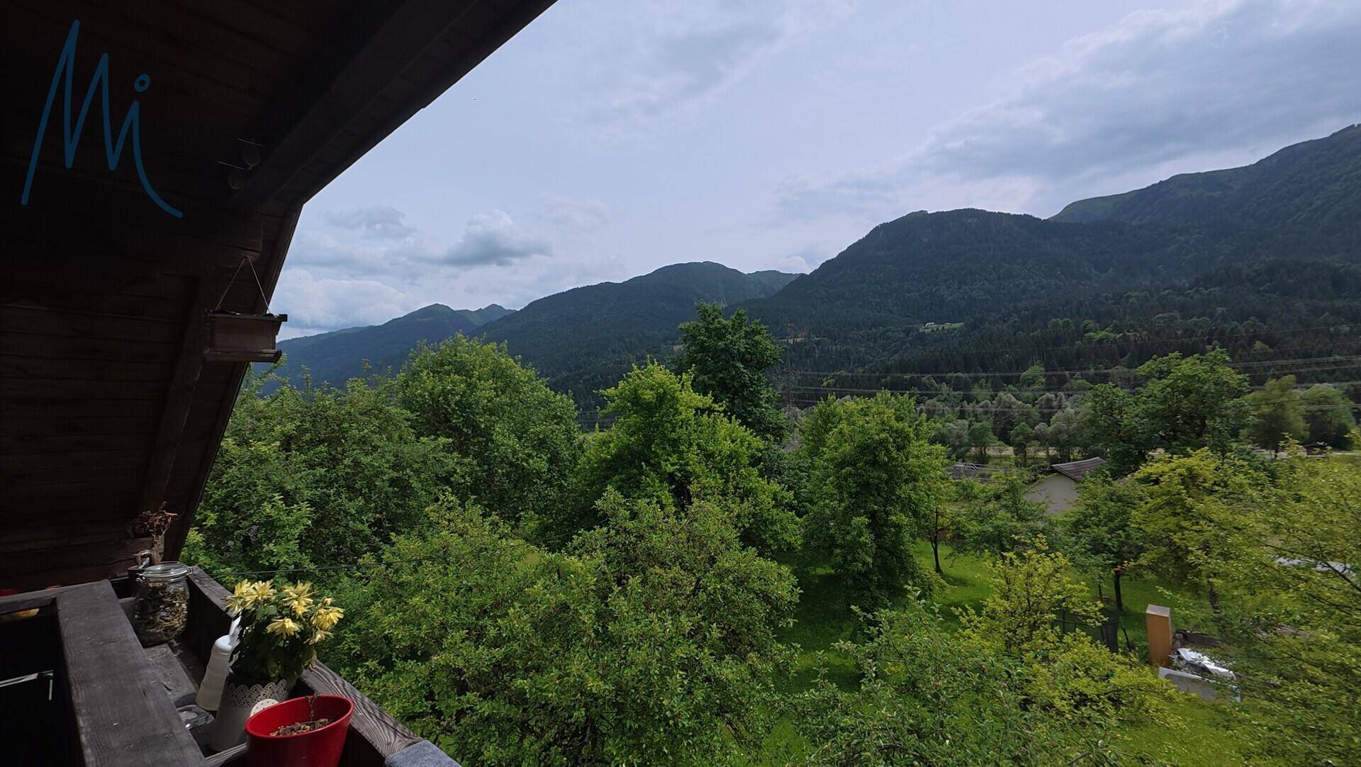 Weitläufiger Blick vom Balkon auf die grüne Berglandschaft und das Tal.