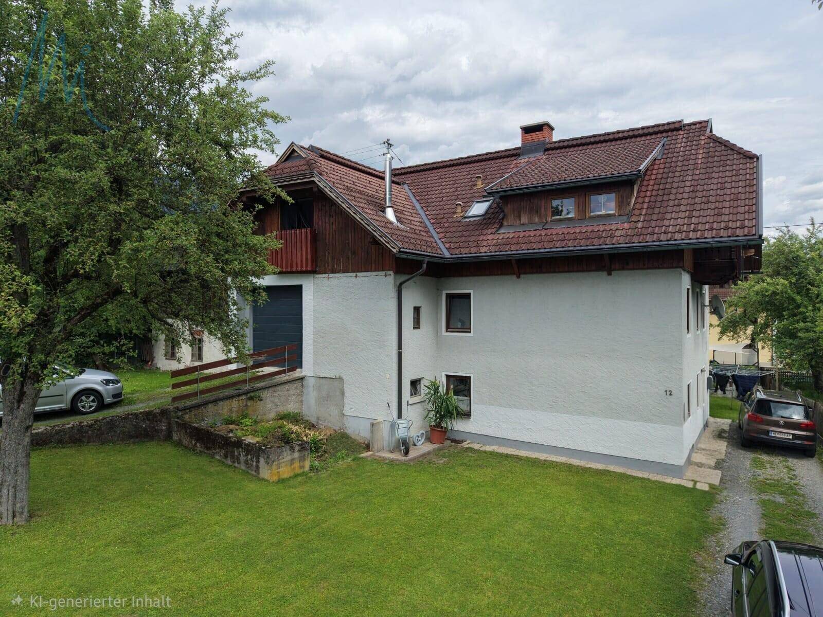 Seitenansicht des Hauses mit Putzfassade, Satteldach und Garagenzufahrt, umgeben von Grünflächen.