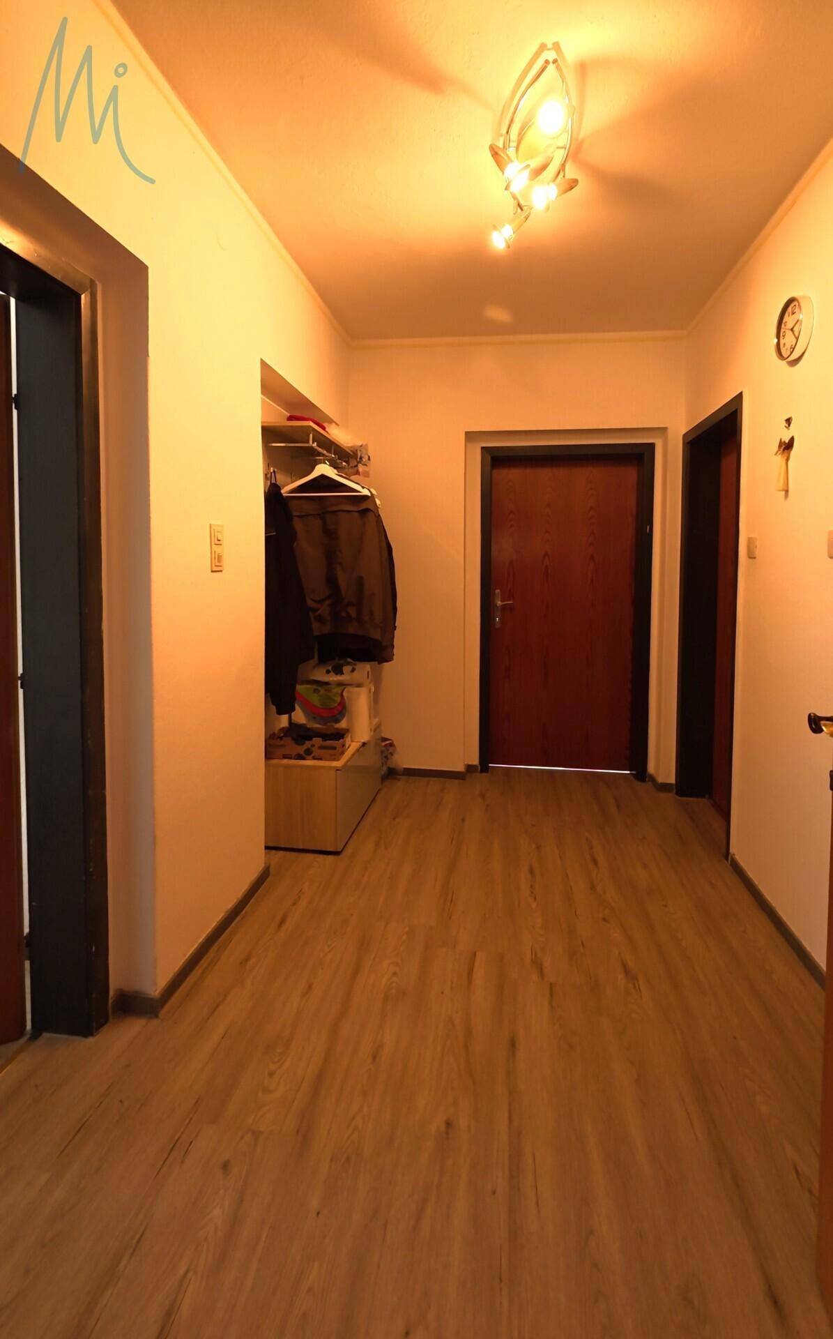 Heller Flur mit Laminatboden und Zugang zu verschiedenen Räumen.