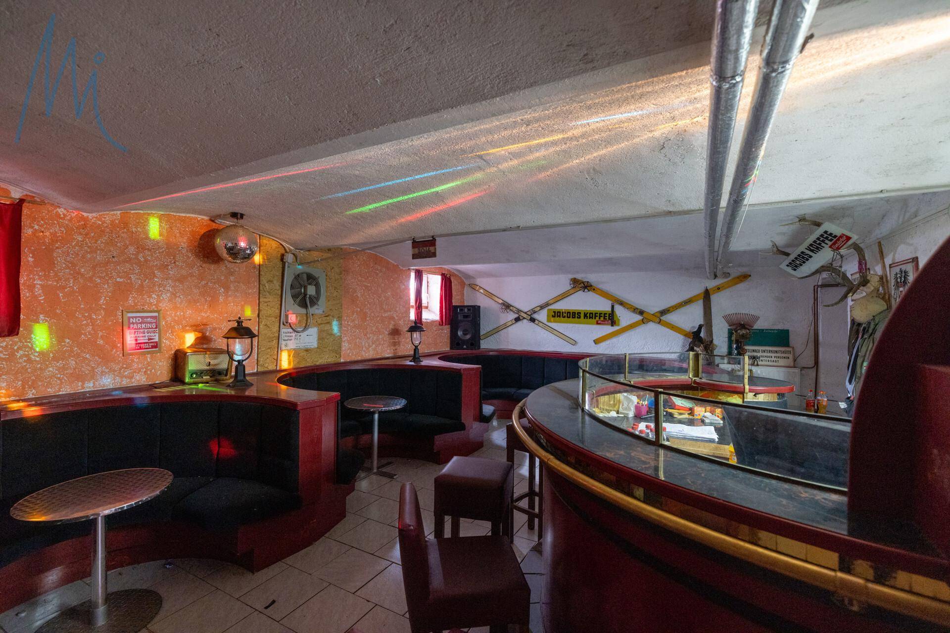 Bar- und Loungebereich mit runden Sitzgelegenheiten und farbigen Lichteffekten, ideal für Geselligkeit.
