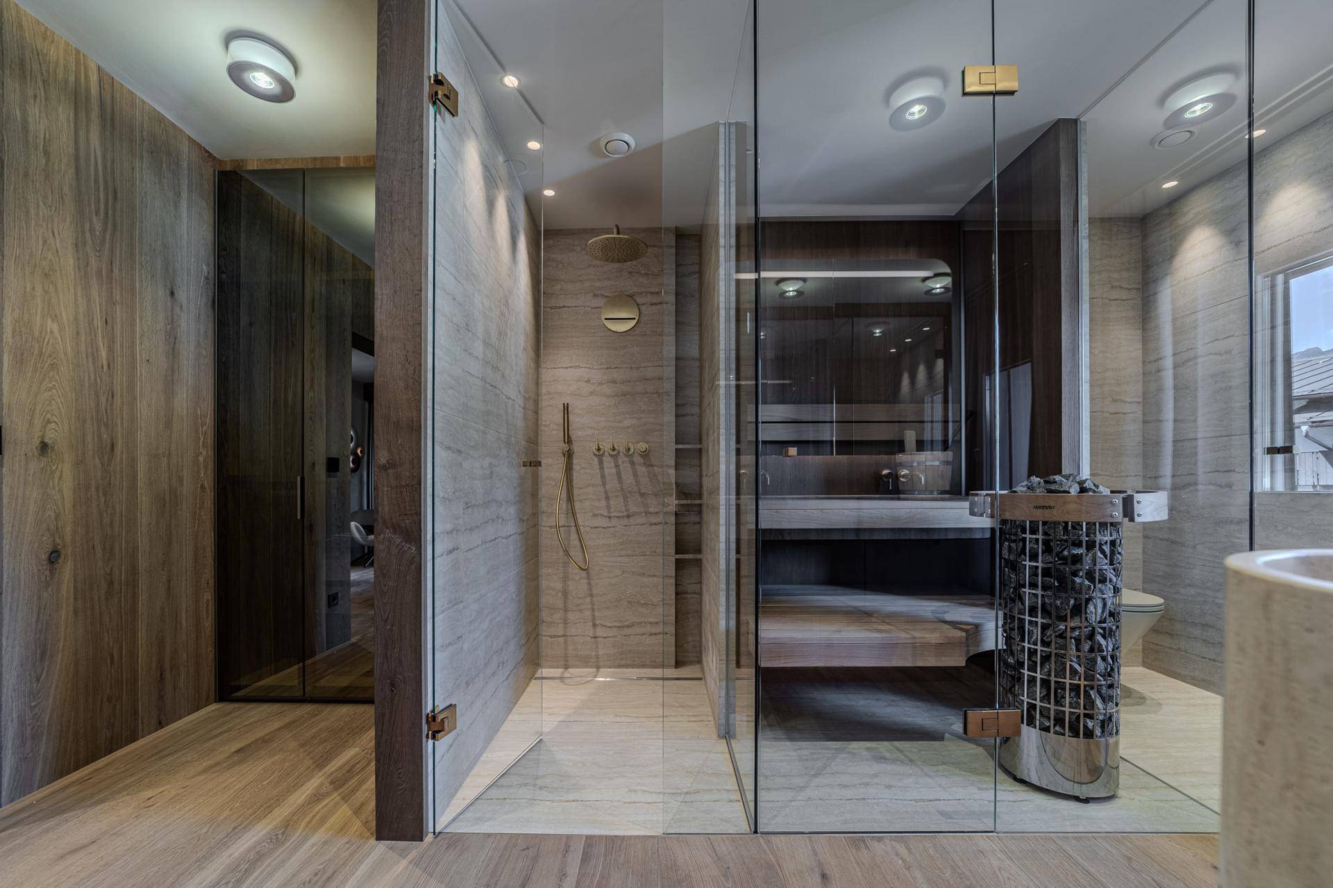 Luxuriöser Wellnessbereich mit Sauna, begehbarer Dusche und hochwertigen Materialien.