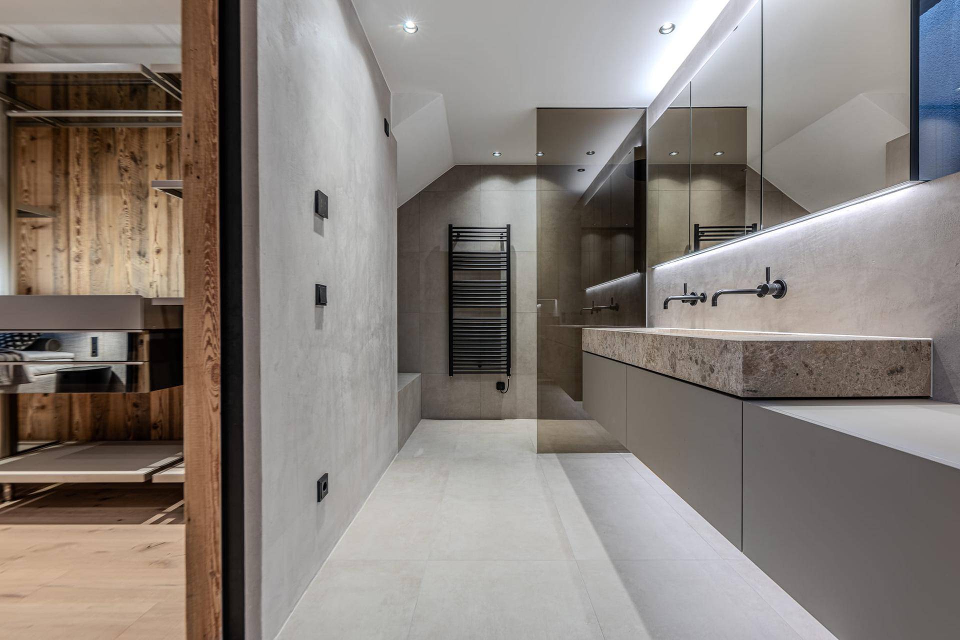 Elegantes Badezimmer mit Doppelwaschbecken, begehbarer Dusche und beheiztem Handtuchhalter.