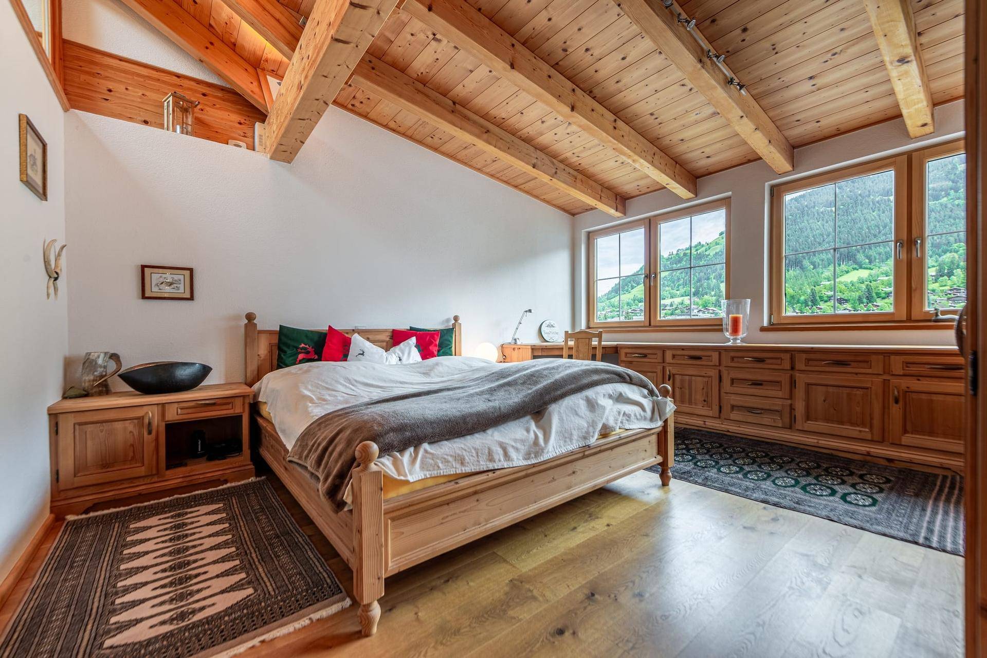 Gemütliches Schlafzimmer mit Holzbett, Einbauschränken und weitem Blick in die grüne Natur.