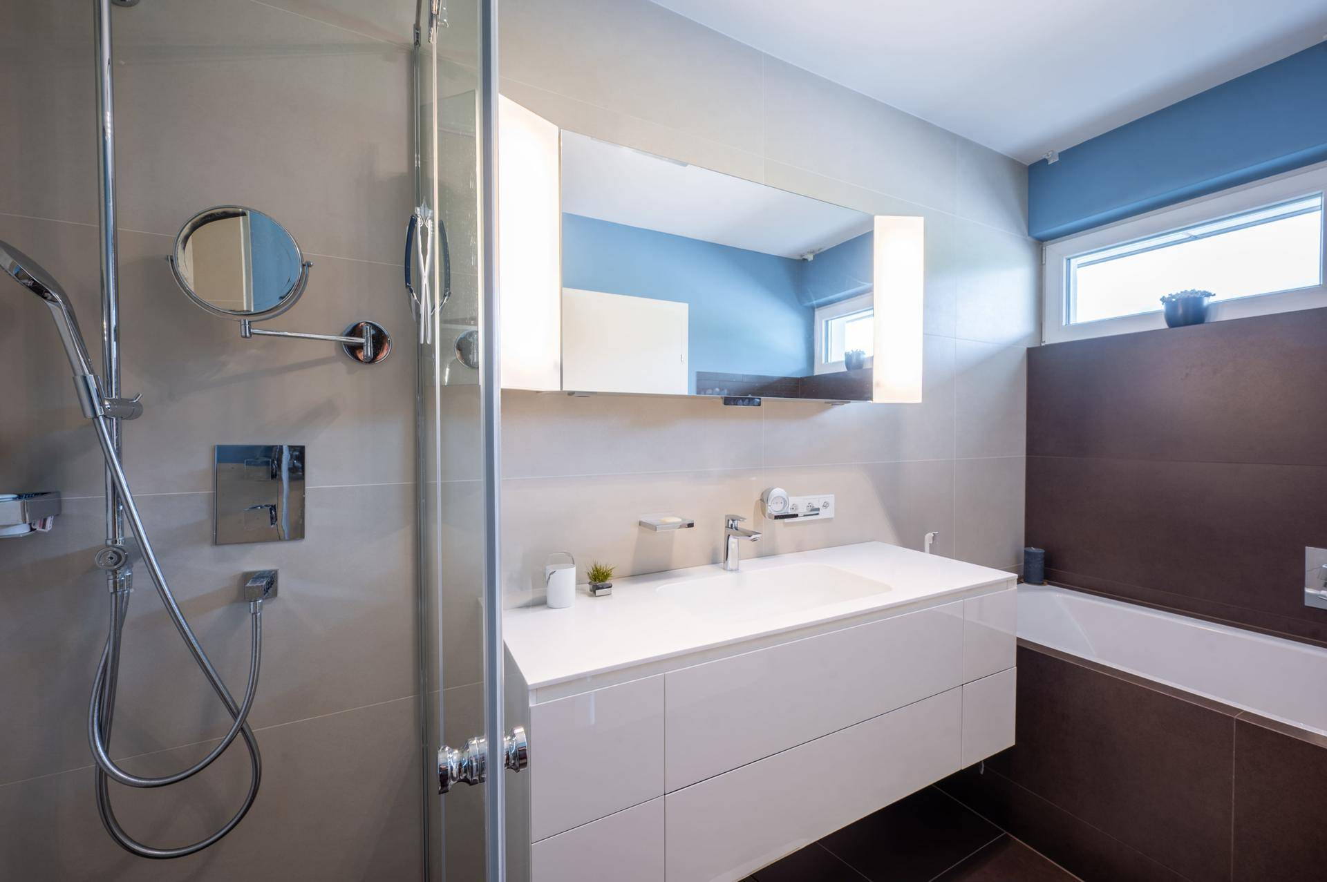 Modernes Badezimmer mit Dusche, Badewanne, großem Waschtisch und Spiegelschrank.