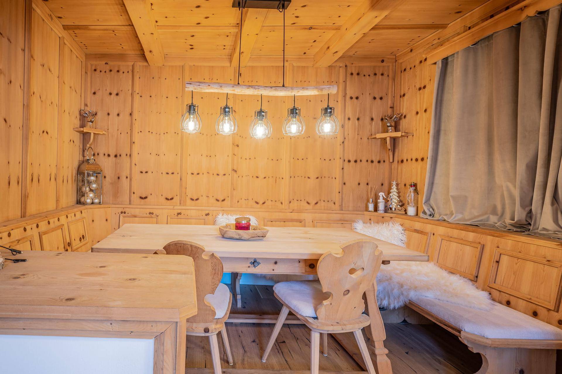Traditioneller Essbereich im alpinen Stil mit Holztäfelung, Eckbank und rustikalem Esstisch.