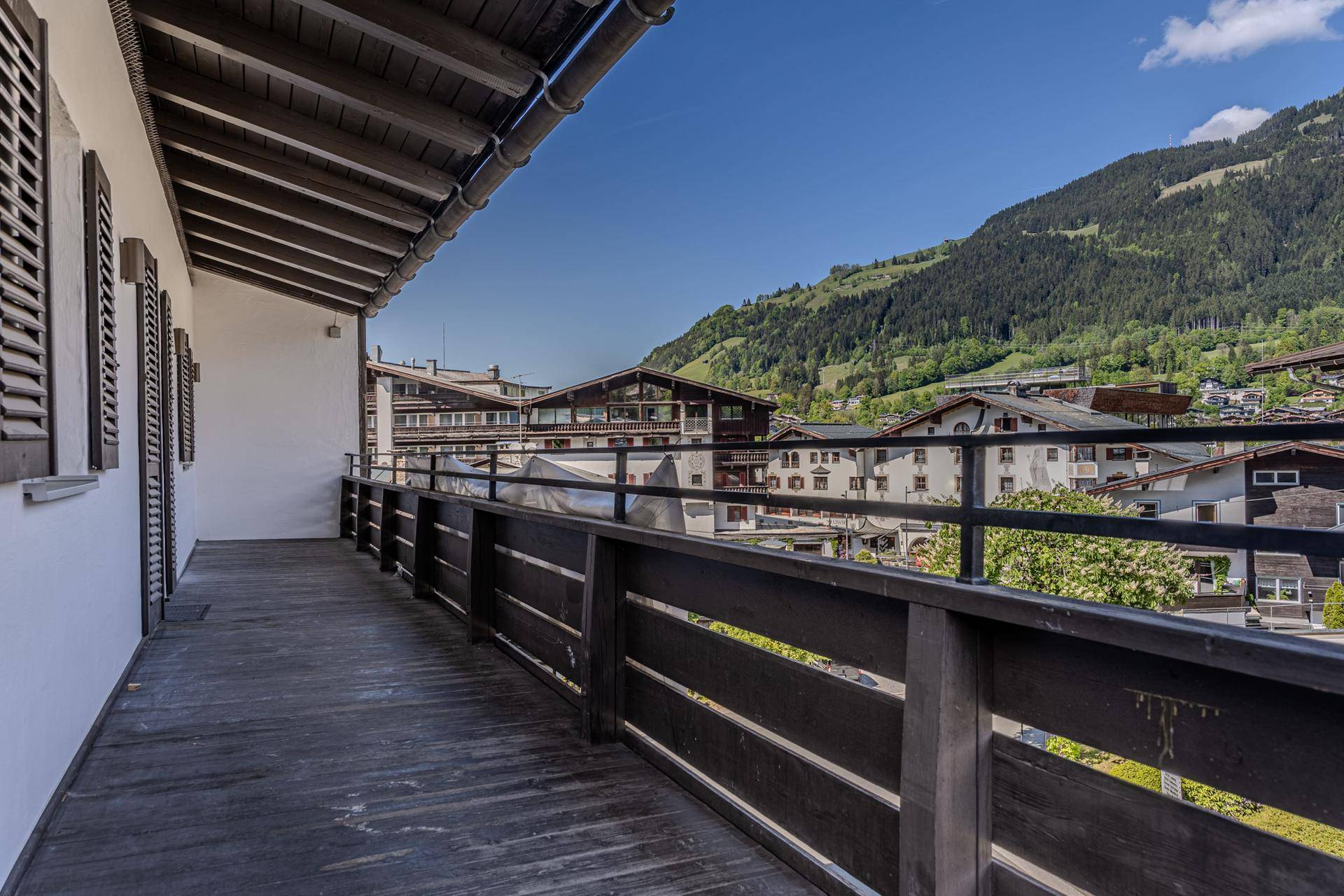 Großer Holzbalkon mit Bergblick und traditioneller Architektur in der Umgebung.