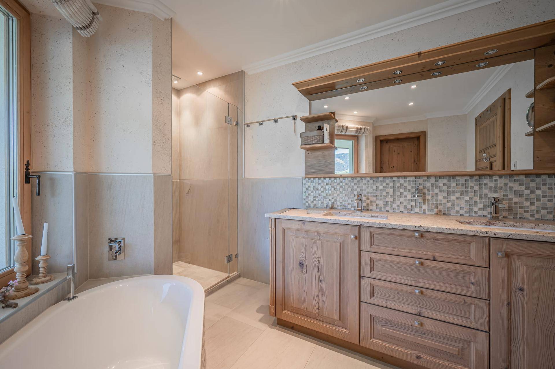 Helles Badezimmer mit Badewanne, Dusche und Doppelwaschbecken in modernem Design.