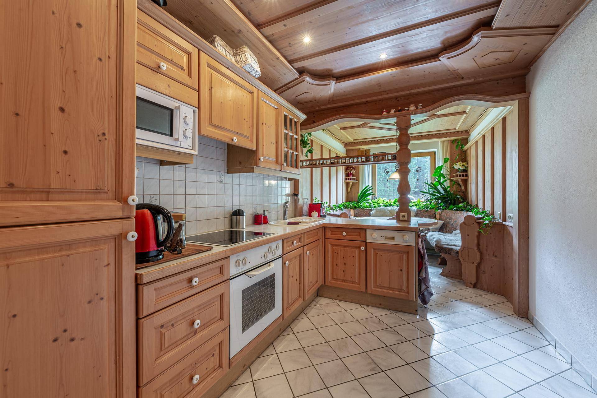 Funktionale Holzküche mit Einbaugeräten und angrenzendem Essbereich im Landhausstil.