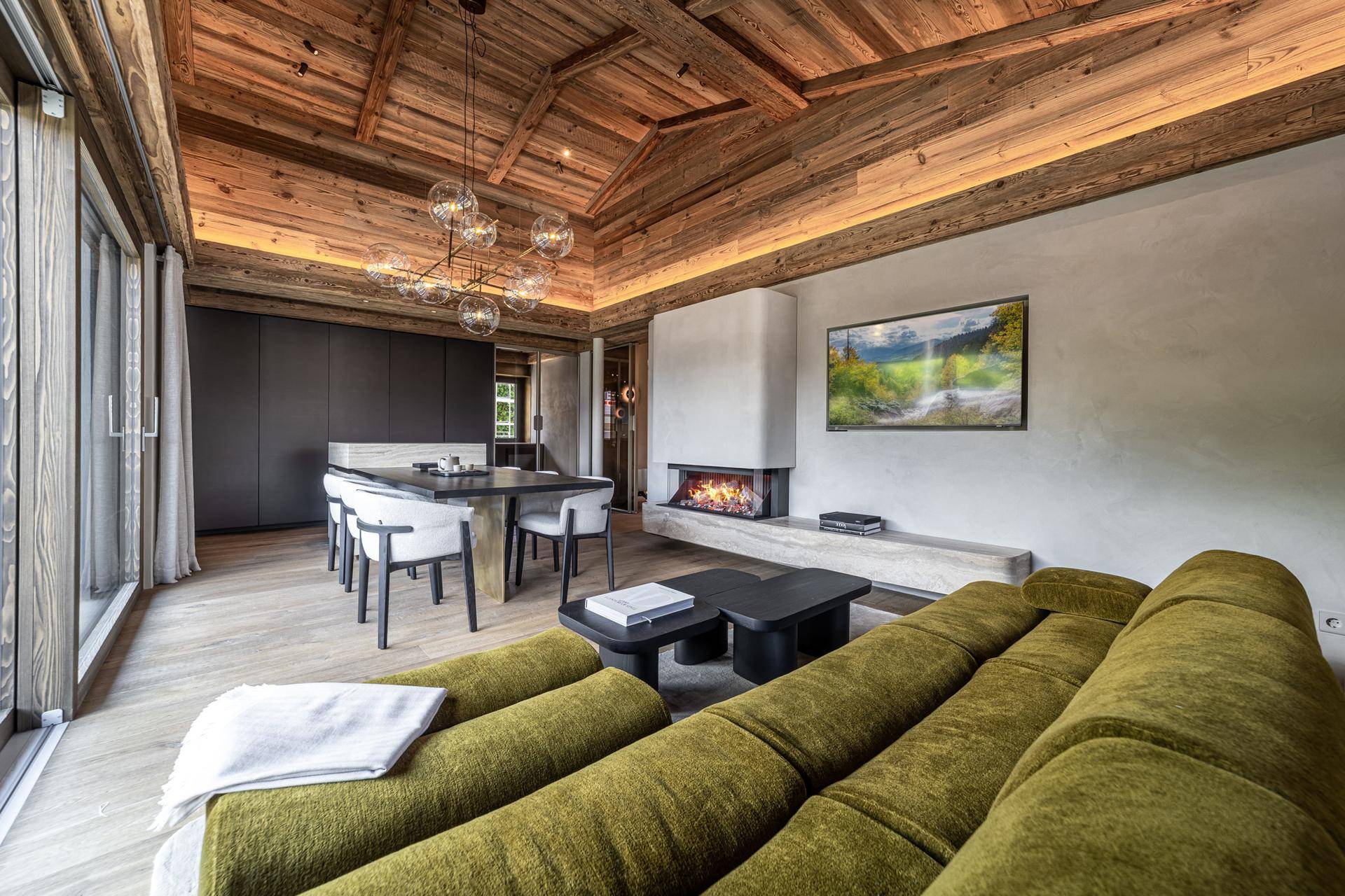Geräumiger Wohn-Essbereich mit Holzbalkendecke, modernem Kamin und stilvoller Einrichtung.