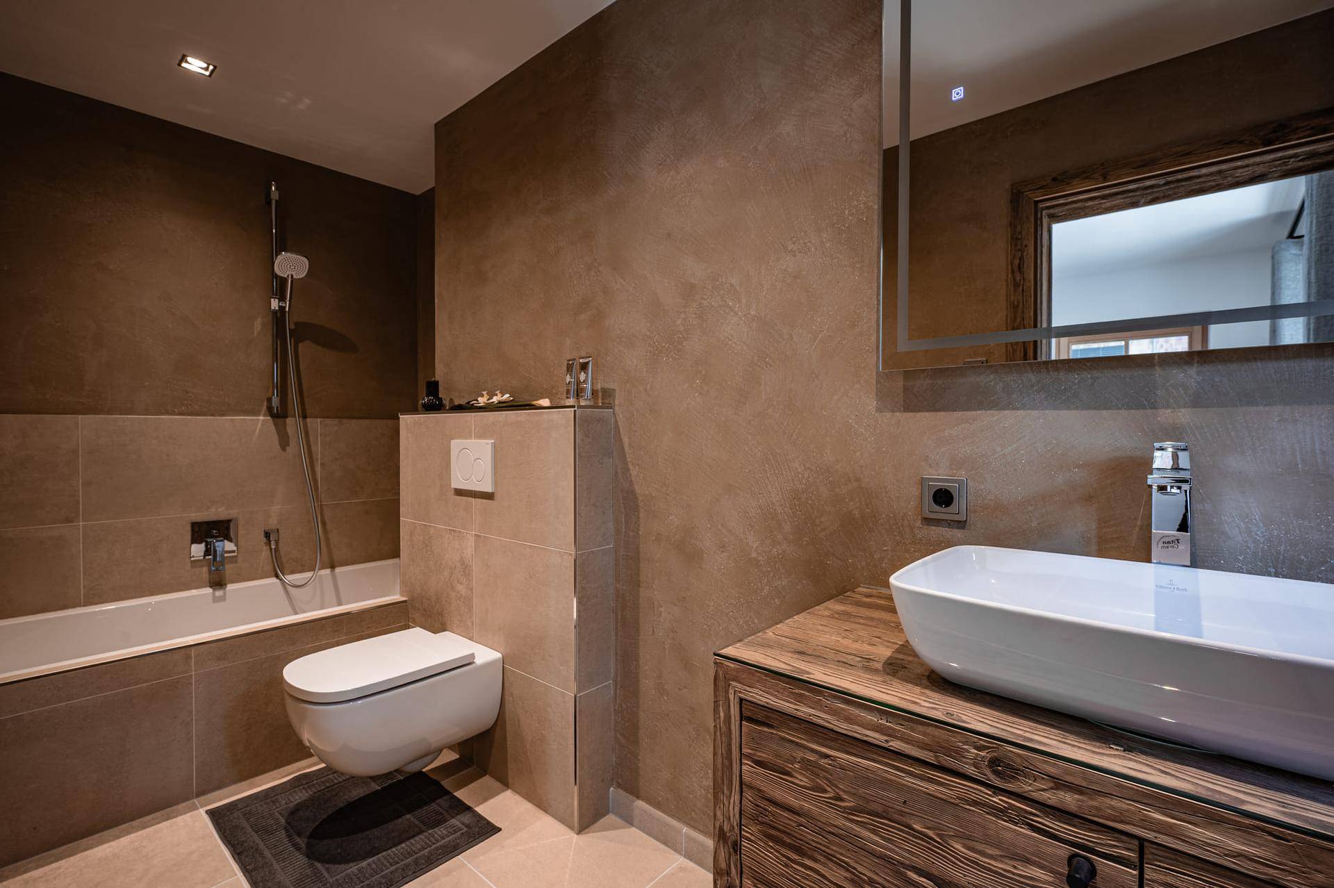 Elegantes Badezimmer mit Badewanne, wandhängendem WC und modernem Waschtisch.