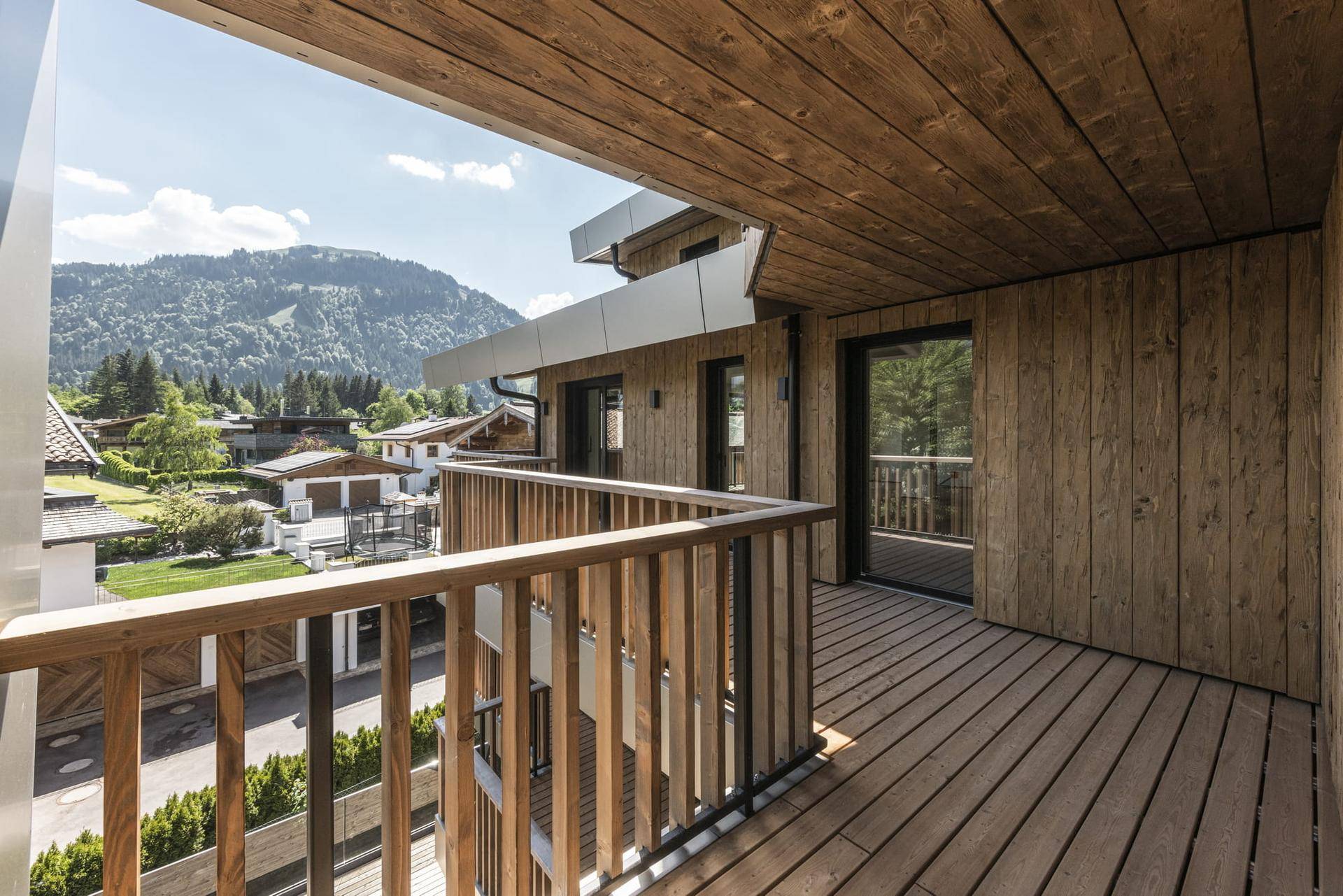 Geräumiger Holzbalkon mit traditionellem Geländer und weitem Blick auf die Berglandschaft.