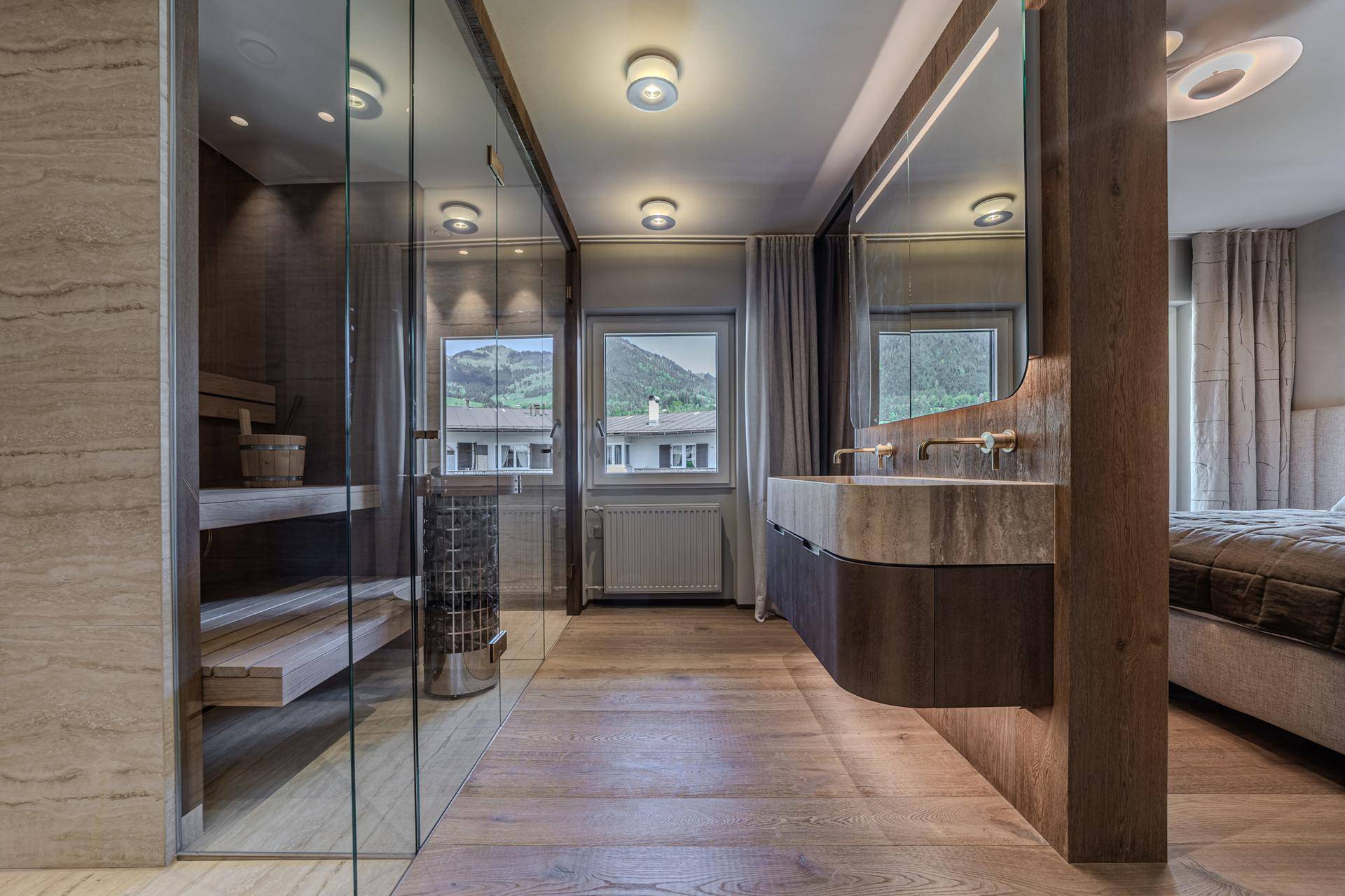 Elegantes Badezimmer mit integrierter Sauna, Doppelwaschbecken und Bergblick aus dem Fenster.