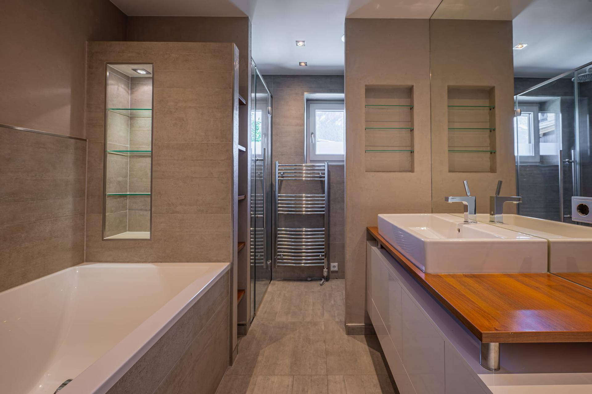 Modernes Badezimmer mit Badewanne, Doppelwaschbecken und beheiztem Handtuchhalter.