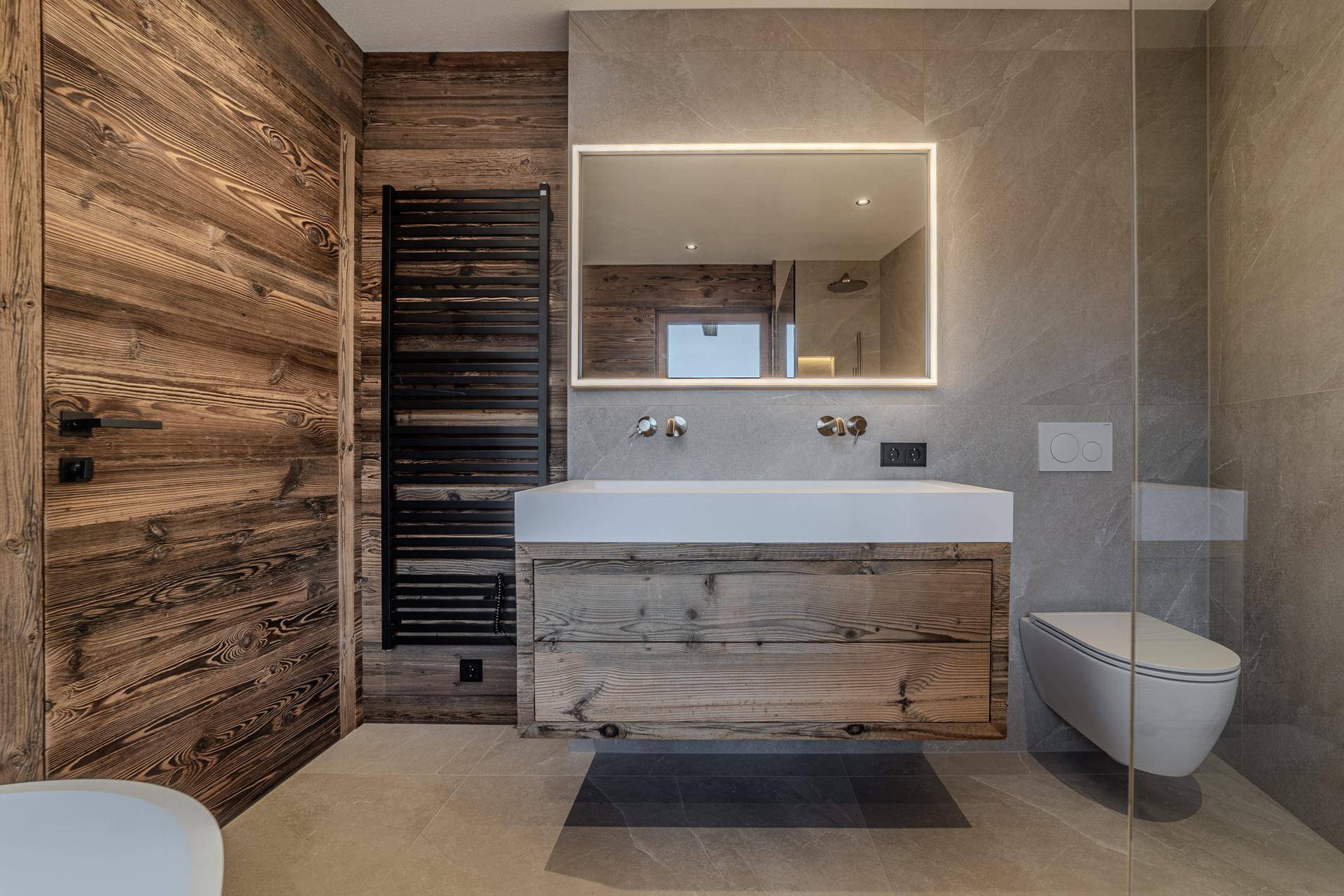 Modernes Badezimmer mit Holzwandverkleidung, großem Waschtisch und beheiztem Handtuchhalter.
