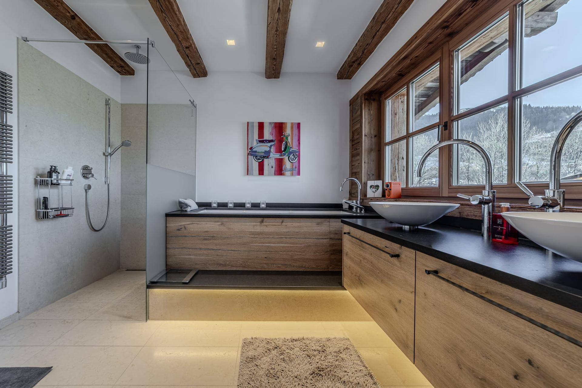 Modernes Badezimmer mit begehbarer Dusche, Doppelwaschbecken und Holzbalkendecke mit Bergblick.