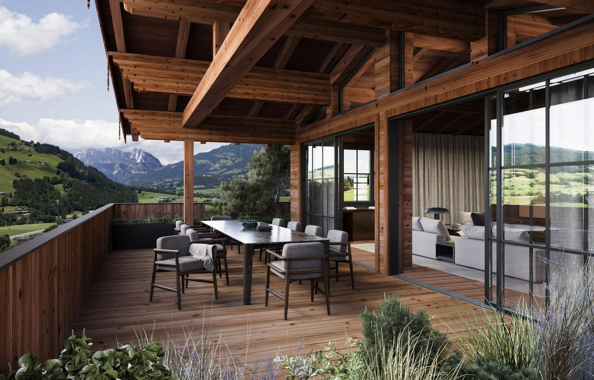 Große Holzterrasse mit Esstisch, bequemen Sitzgelegenheiten und beeindruckendem Bergblick.