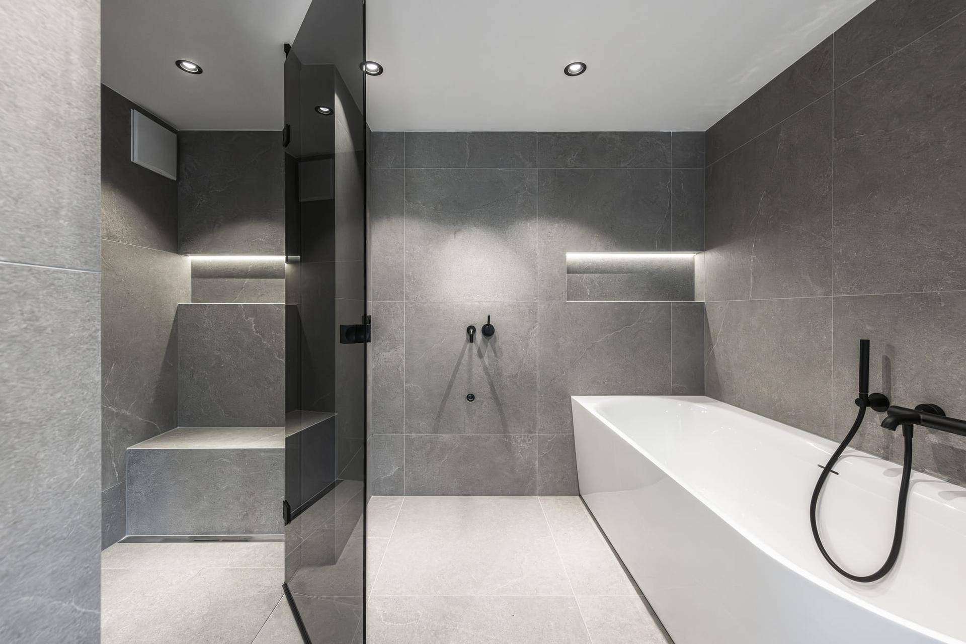 Modernes Badezimmer mit grauen Fliesen, freistehender Badewanne und begehbarer Dusche.