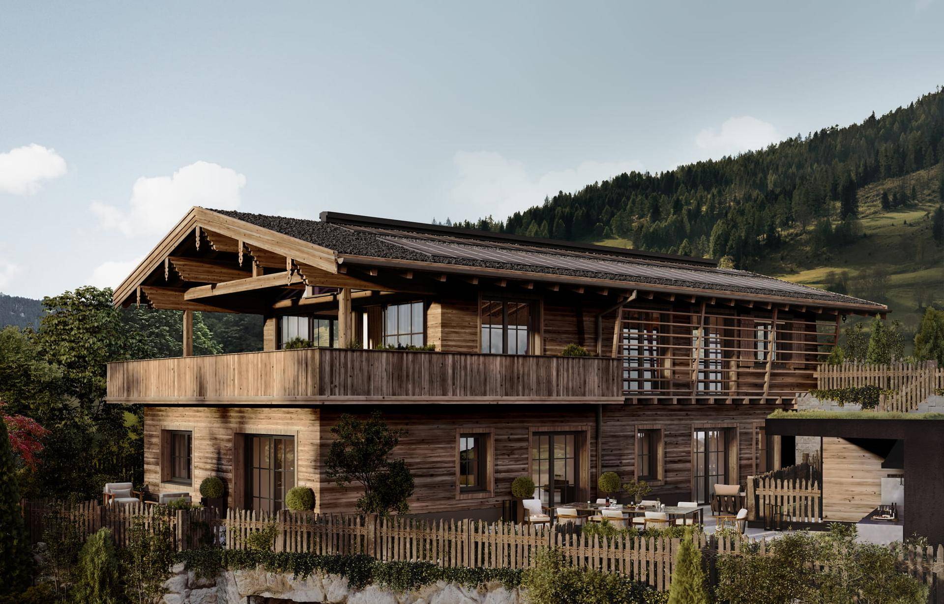 Traditionelles Holzhaus im alpinen Stil mit Balkonen und Terrassen in grüner Umgebung.