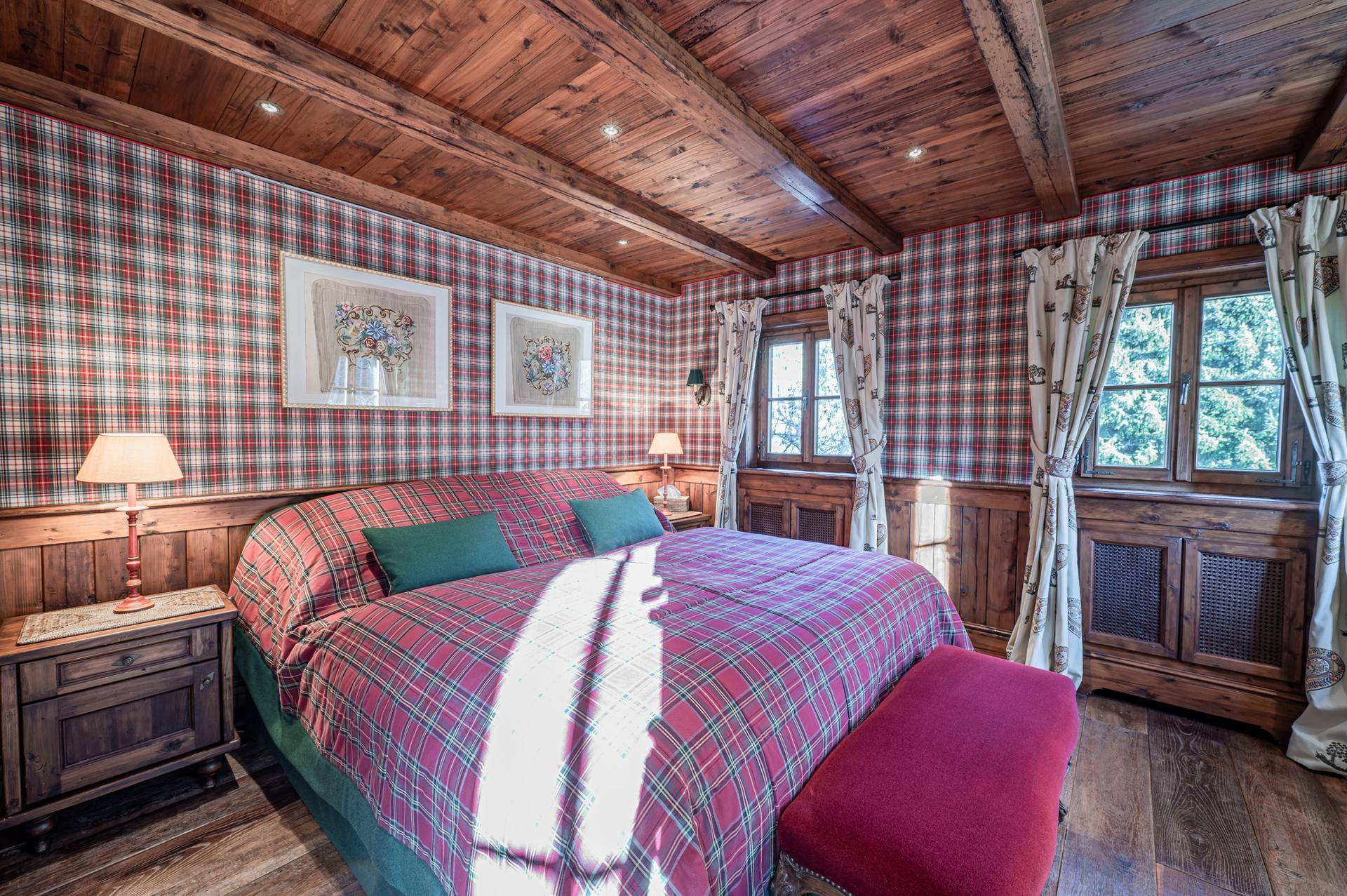 Gemütliches Schlafzimmer mit karierter Tapete, Holzbalkendecke und traditionellen Möbeln.