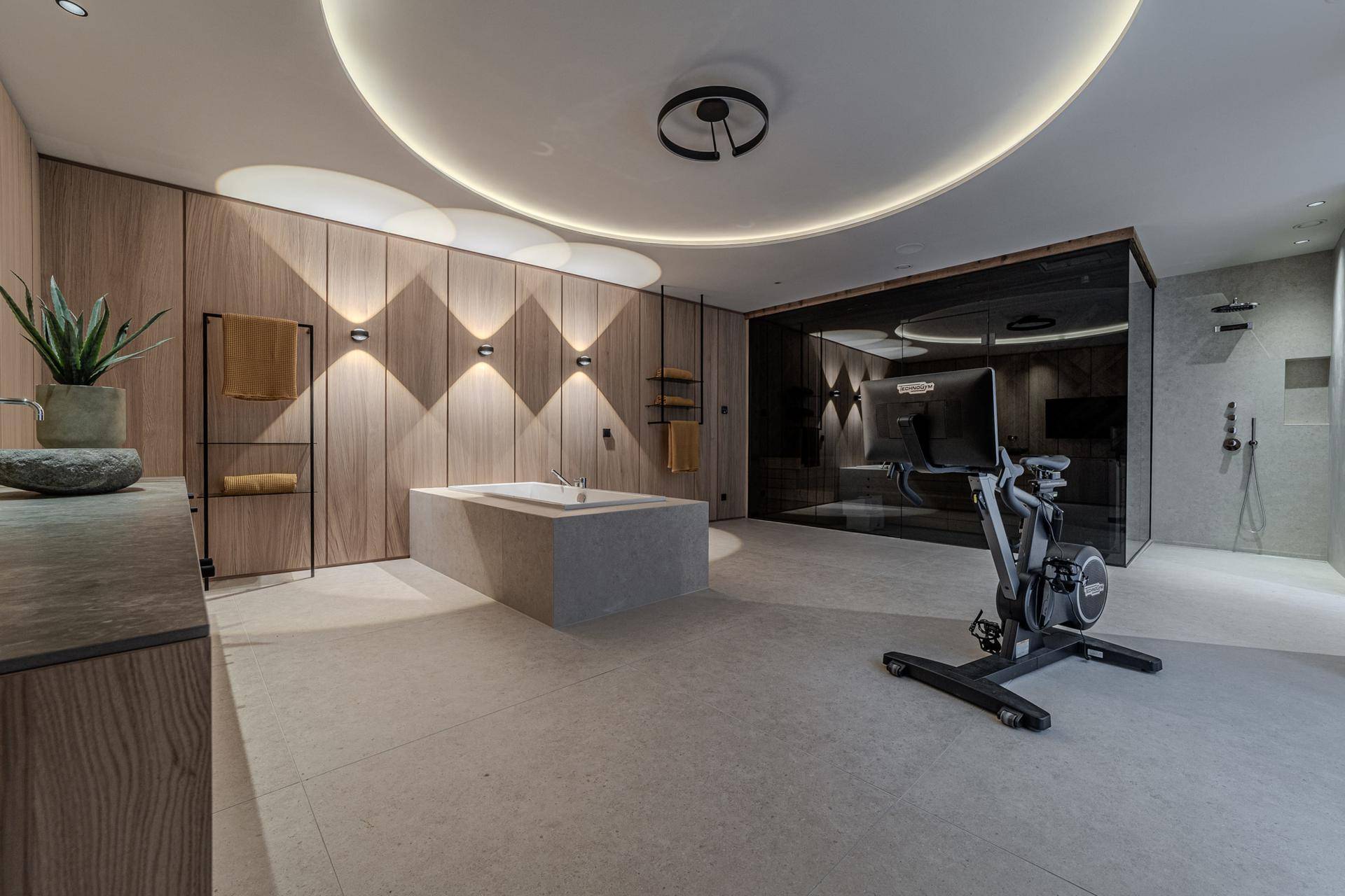 Großzügiges Spa-Badezimmer mit Badewanne, Dusche und integriertem Fitnessbereich in modernem Design.