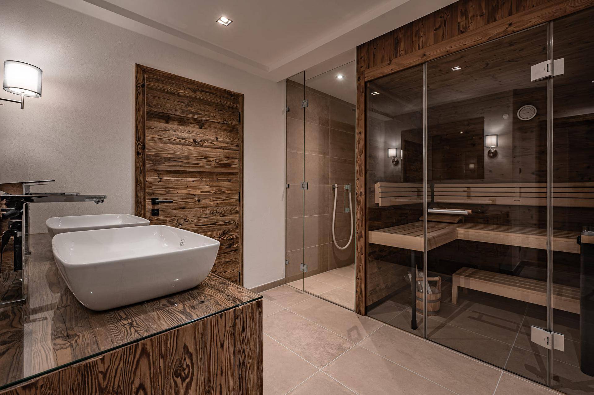 Modernes Badezimmer mit Doppelwaschbecken, begehbarer Dusche und integrierter Sauna.