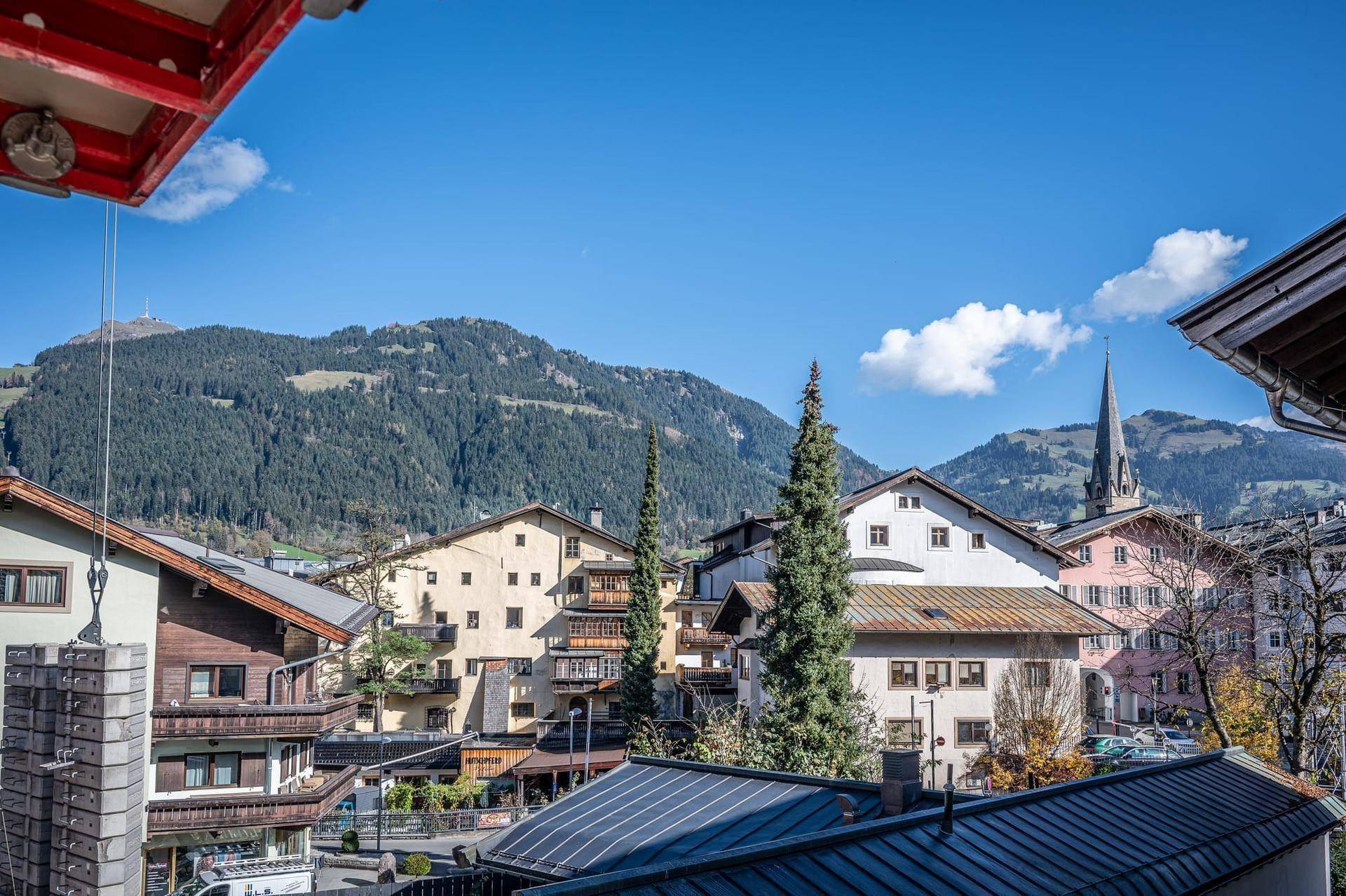 Weitläufiger Blick über das malerische Dorf mit traditionellen Häusern und den majestätischen Bergen.