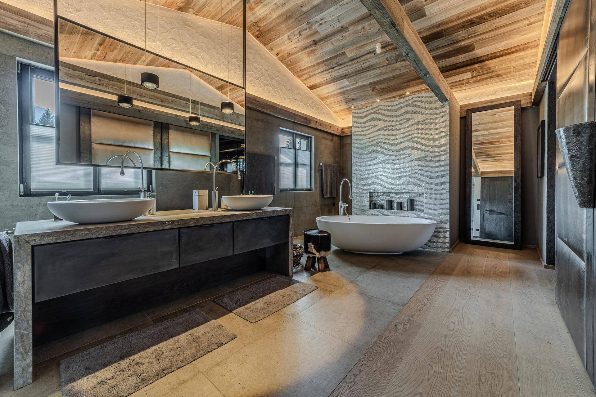 Elegantes Badezimmer mit freistehender Badewanne, Doppelwaschbecken und Holzbalkendecke.