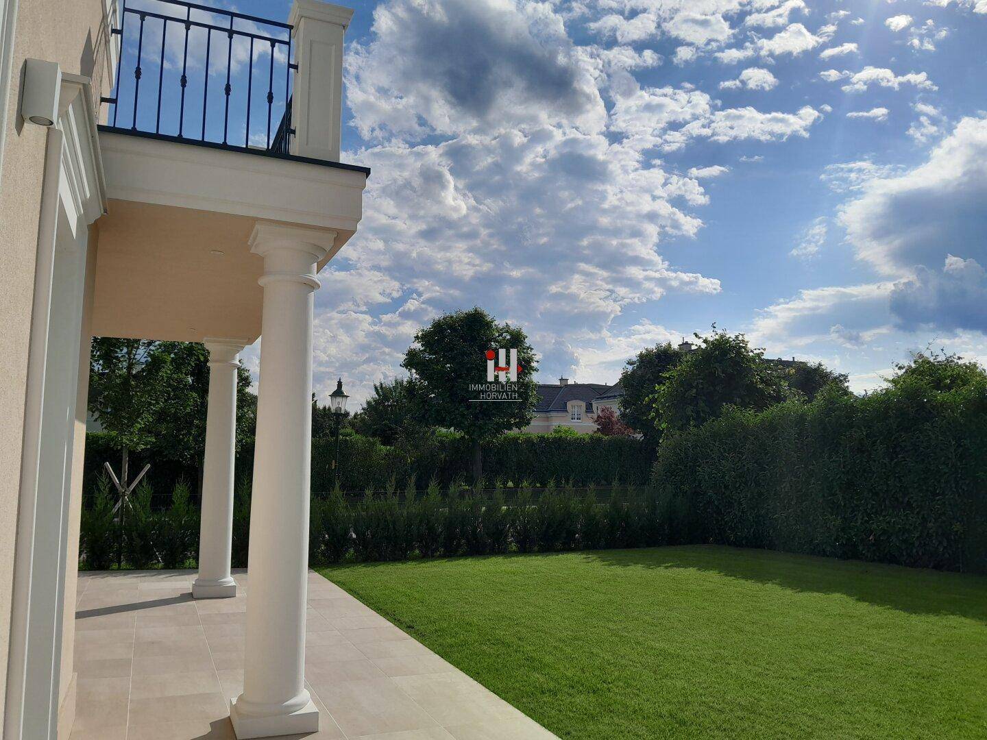 Gepflegter Gartenbereich mit Rasenfläche und Säulen, ideal für Entspannung im Freien.