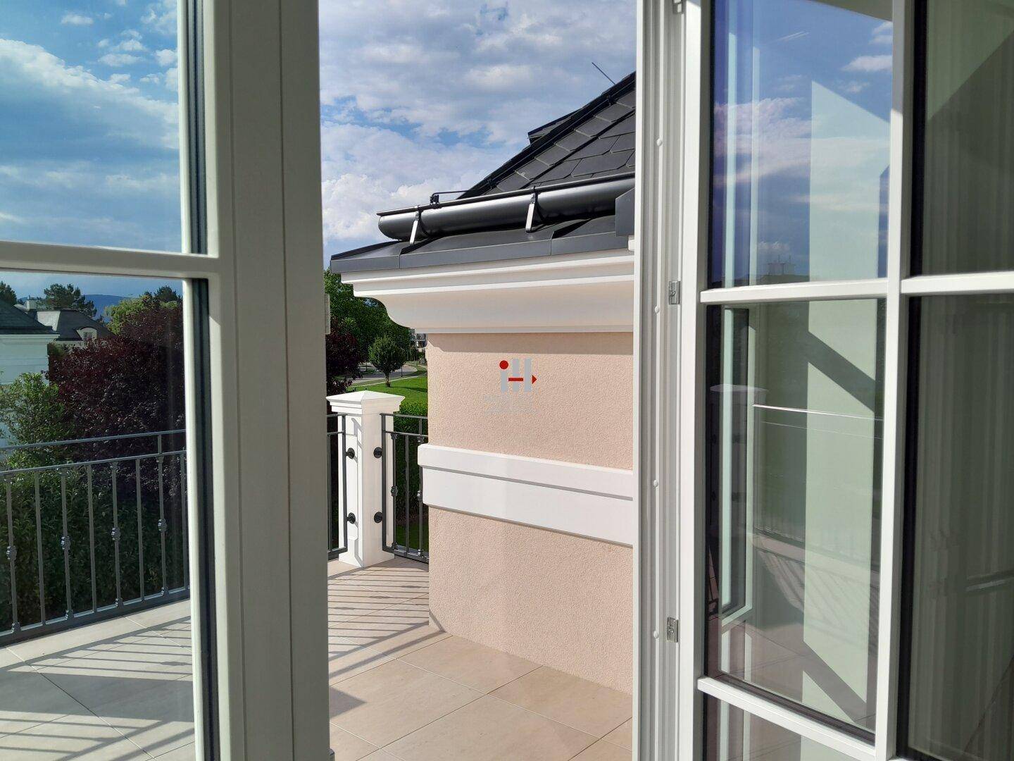 Kleiner Balkon mit schmiedeeisernem Geländer und Blick auf die Umgebung.
