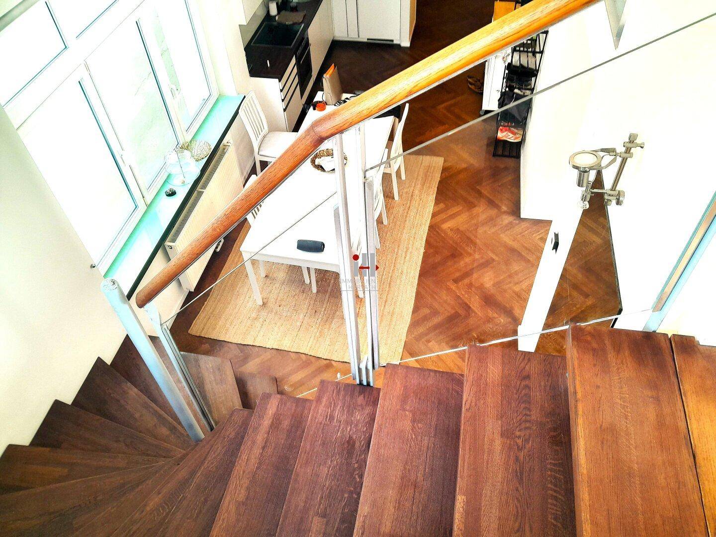 Blick von der Treppe auf den offenen Küchen- und Essbereich mit Fischgrätparkett.