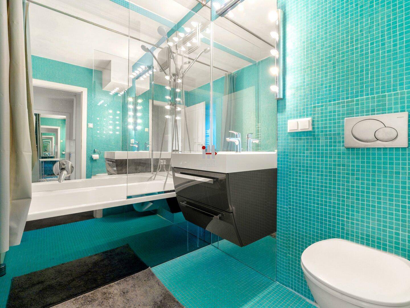 Modernes Badezimmer mit türkisfarbenen Mosaikfliesen, großem Spiegel und Hänge-WC.
