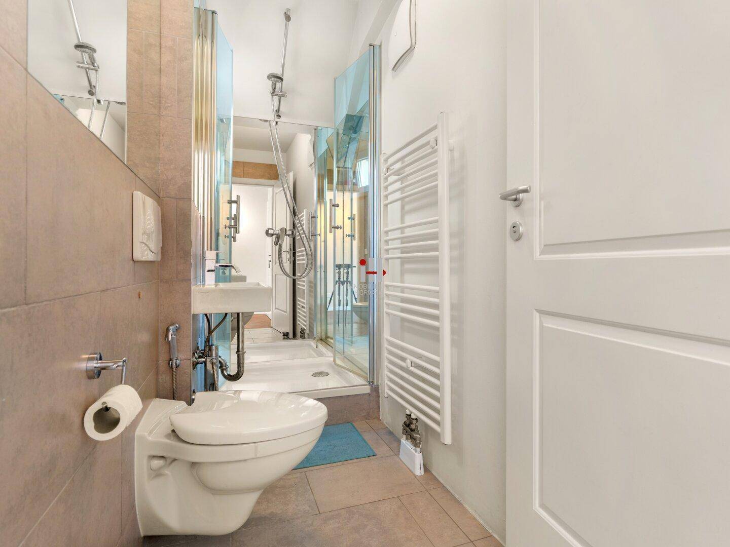 Funktionales Badezimmer mit Dusche, Hänge-WC und beheiztem Handtuchhalter.