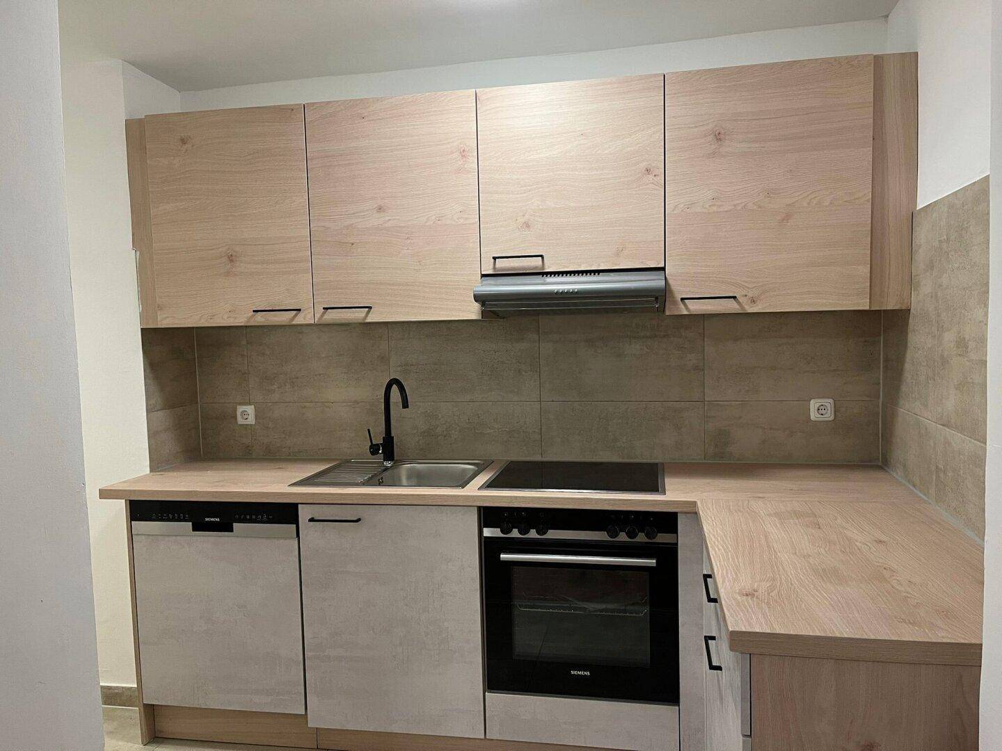 Moderne Einbauküche mit hellen Holzfronten, integrierten Geräten und praktischer Arbeitsfläche.