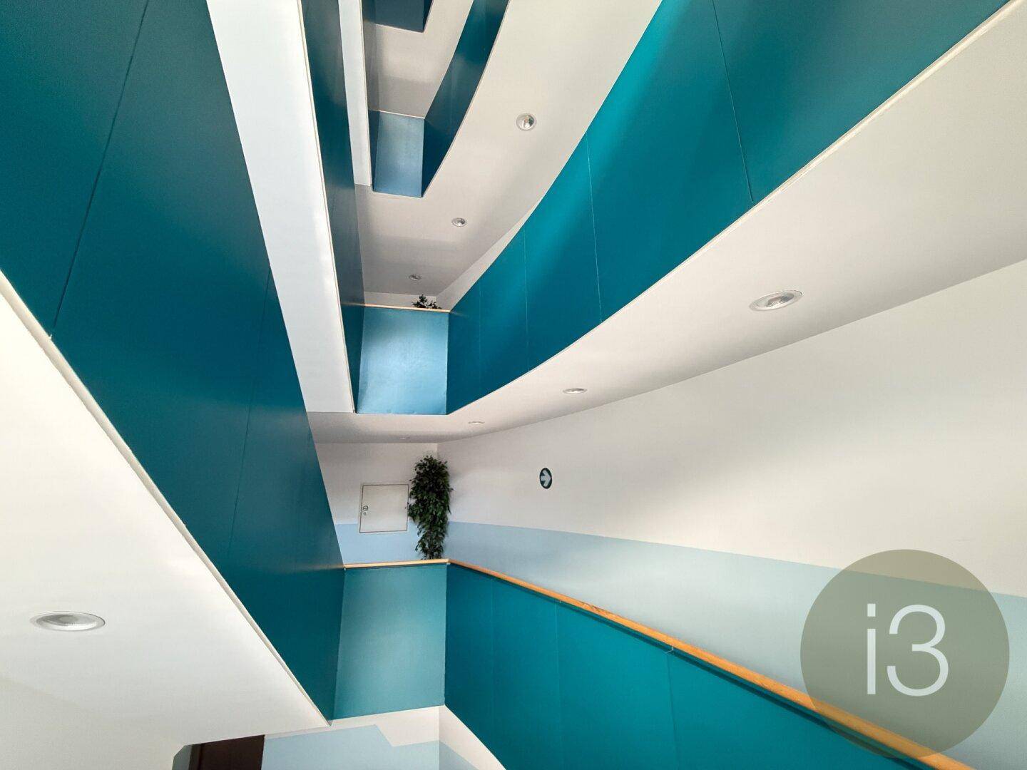 Modernes Treppenhaus mit auffälligen blauen Wänden und indirekter Beleuchtung.