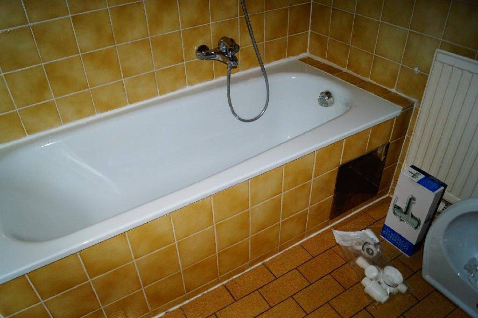 Badezimmer mit eingebauter Badewanne und gelben Fliesen, die einen klassischen Stil zeigen.