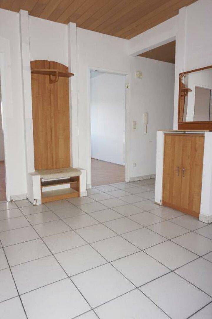 Eingangsbereich mit Fliesenboden, Garderobe und Spiegel, bietet praktischen Stauraum.
