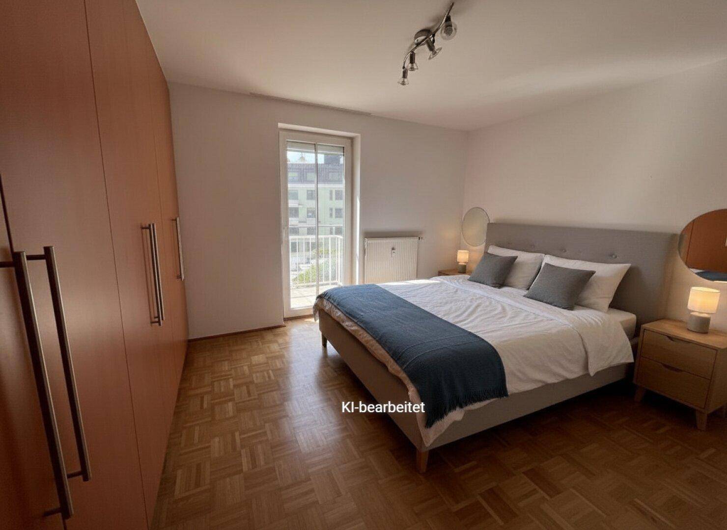 Schlafzimmer mit Parkettboden, großem Kleiderschrank und Zugang zu einem französischen Balkon.