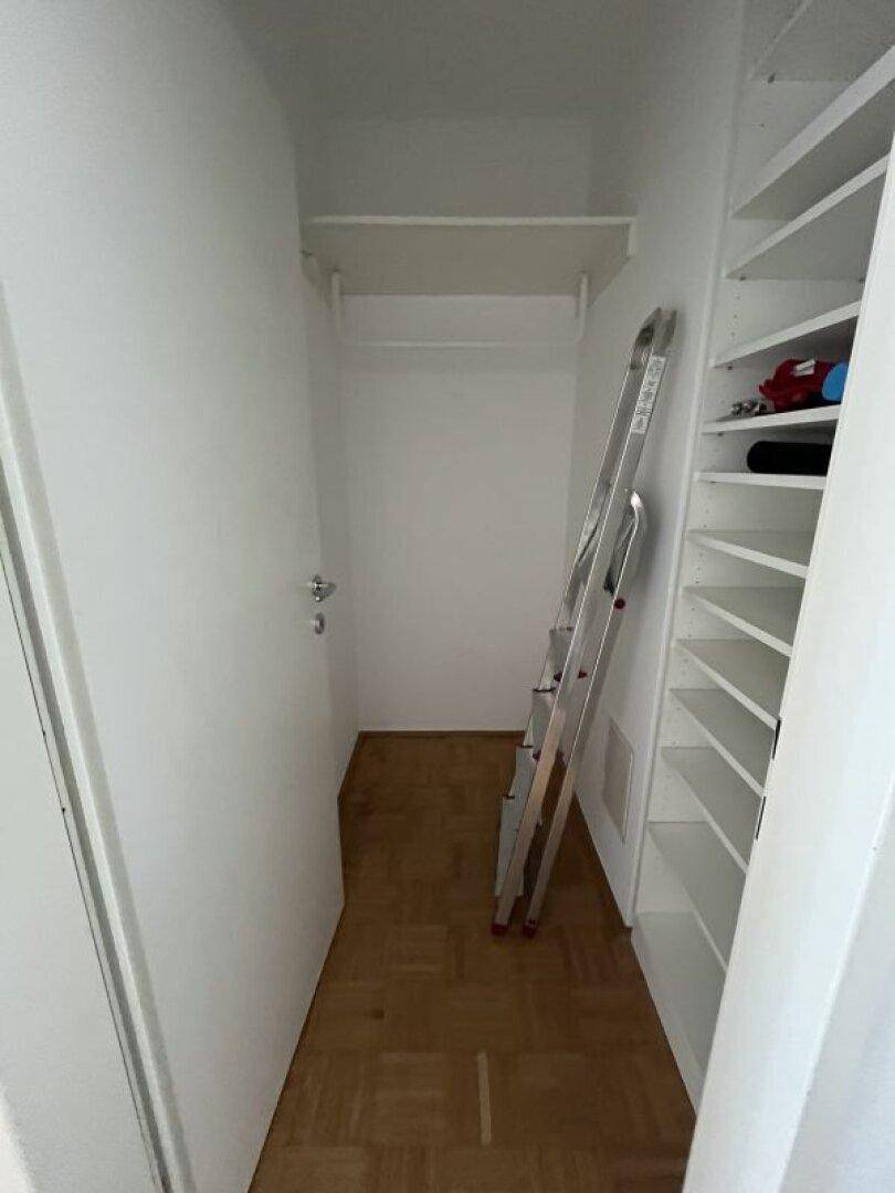 Praktischer Abstellraum mit Regalen und Kleiderstange, ideal für zusätzlichen Stauraum.