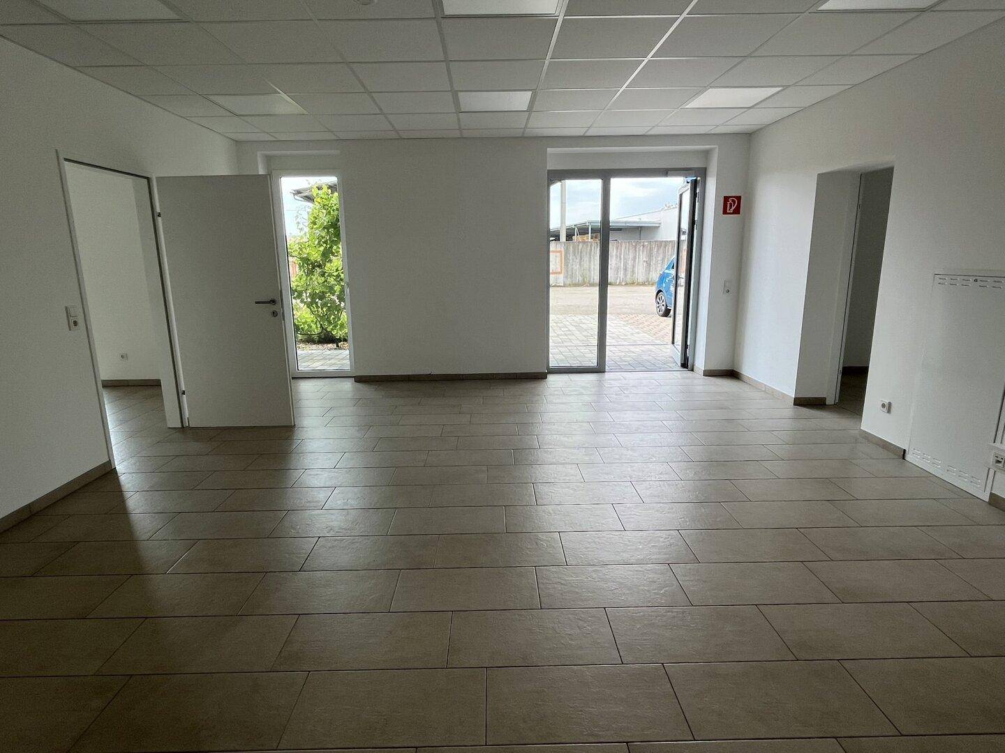 Großer, heller Bürobereich mit mehreren Fenstern und Fliesenboden, bietet viel Tageslicht.