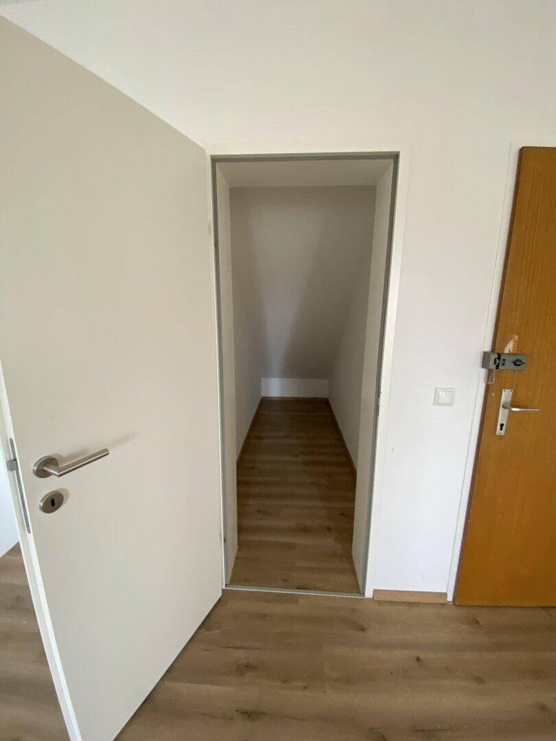 Kleiner Abstellraum mit Laminatboden und Dachschräge, ideal für zusätzlichen Stauraum.