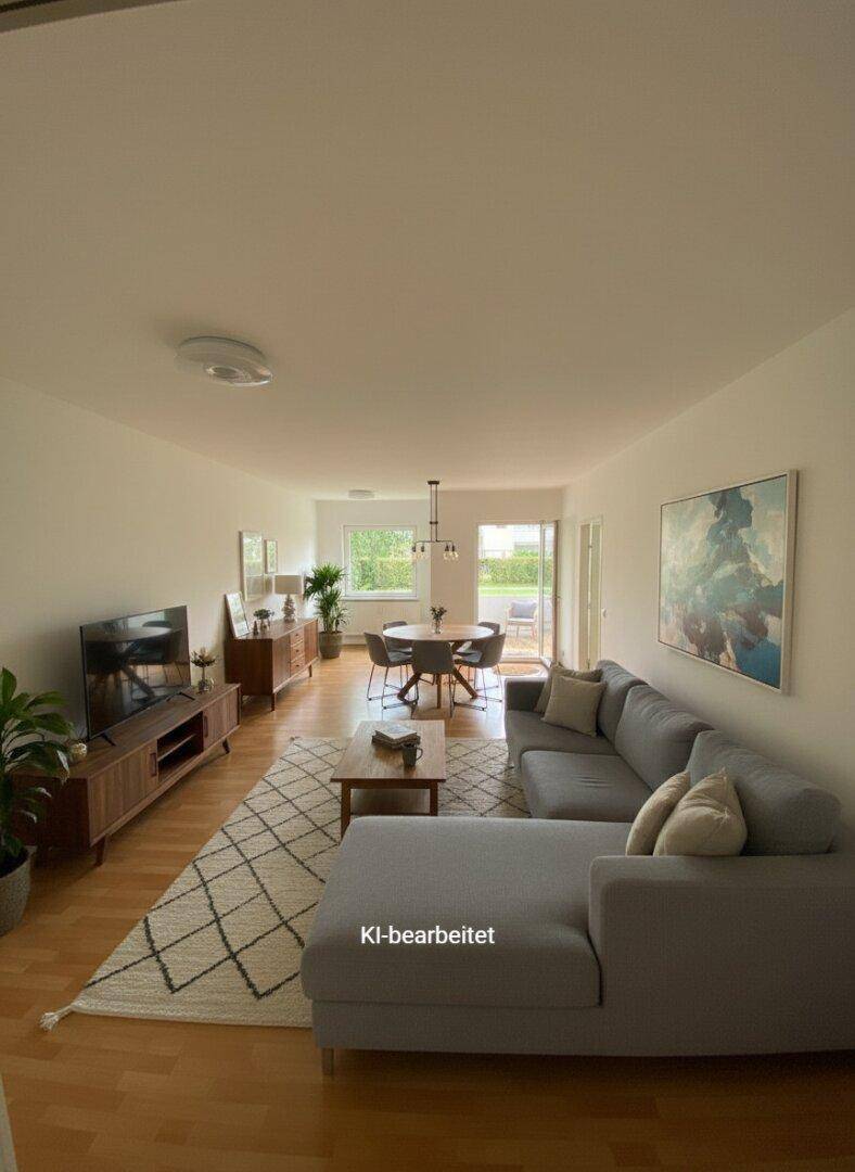 Heller Wohn-Essbereich mit modernem Sofa, Esstisch und Zugang zum Balkon.