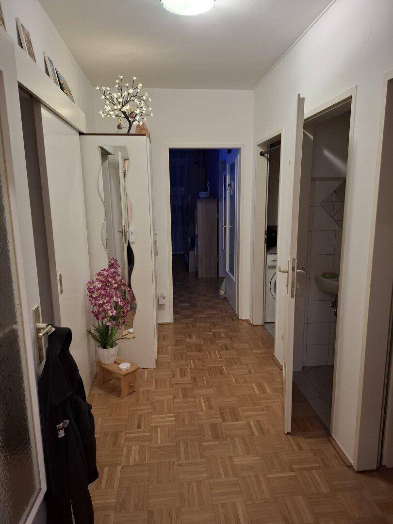 Heller Flur mit Parkettboden und Zugang zu verschiedenen Zimmern der Wohnung.