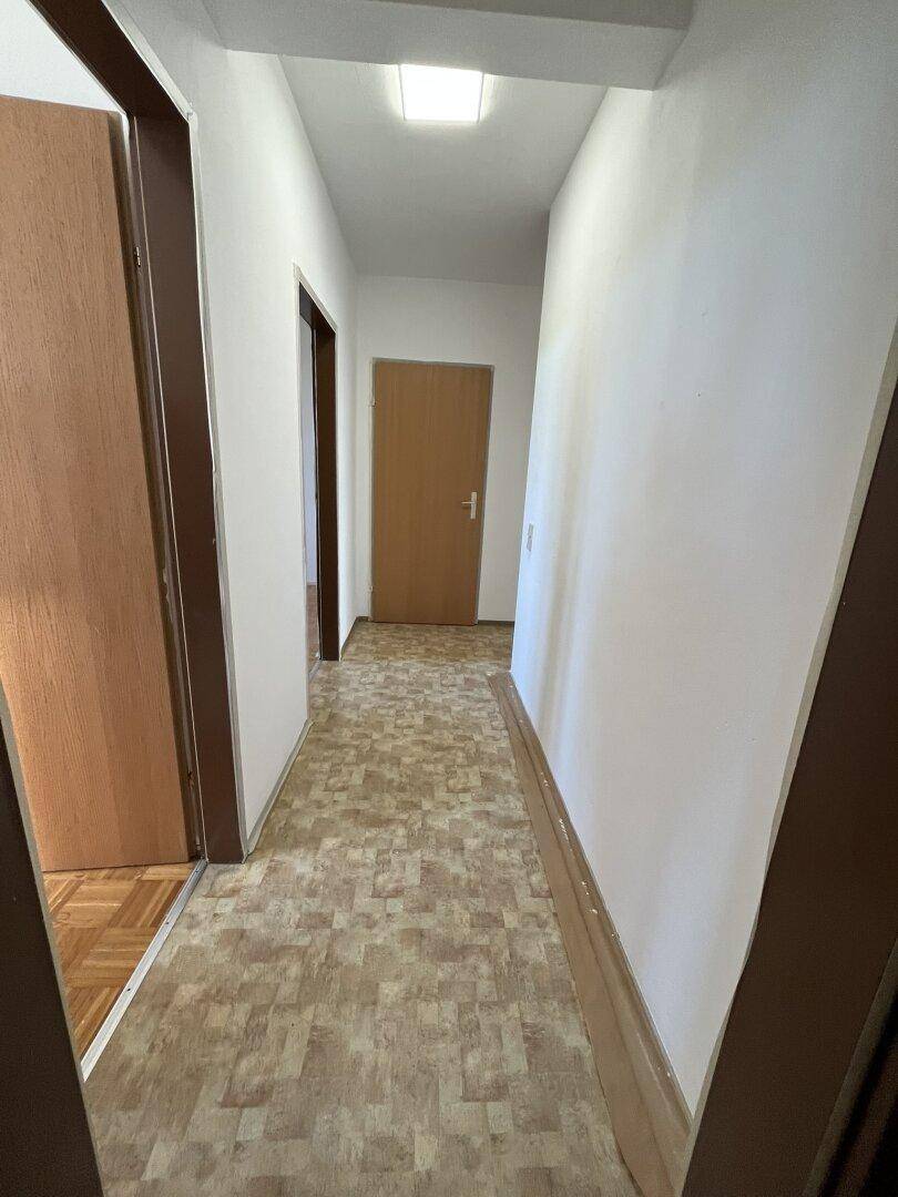 Heller Flur mit Vinylboden und Zugang zu weiteren Zimmern, gut beleuchtet.