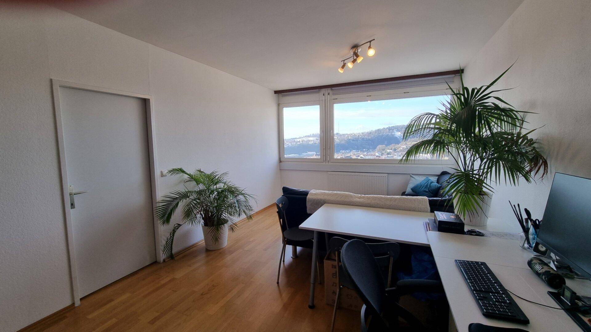 Lichtdurchfluteter Wohnbereich mit Esstisch, Arbeitsplatz und weitem Ausblick.