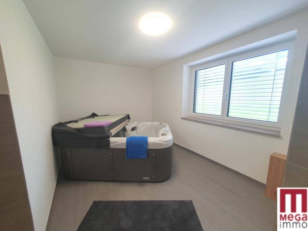Raum mit großem Whirlpool und Fenster, ideal für Entspannung und Wellness.