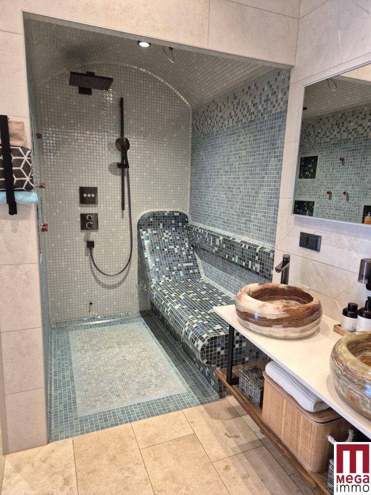 Modernes Badezimmer mit Mosaikfliesen, Regendusche und zwei stilvollen Waschbecken.