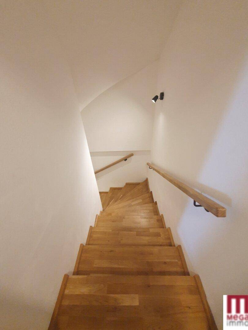 Holztreppe führt in die oberen Stockwerke des Hauses.
